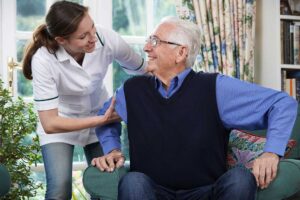 An older adult sitting comfortably in a personalized room with family photos and favorite decorations around them.
