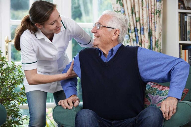 An older adult sitting comfortably in a personalized room with family photos and favorite decorations around them.