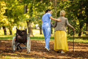 Resident speaking with an assisted living administrator at a desk while holding written notes.