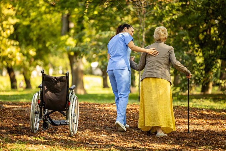 Resident speaking with an assisted living administrator at a desk while holding written notes.